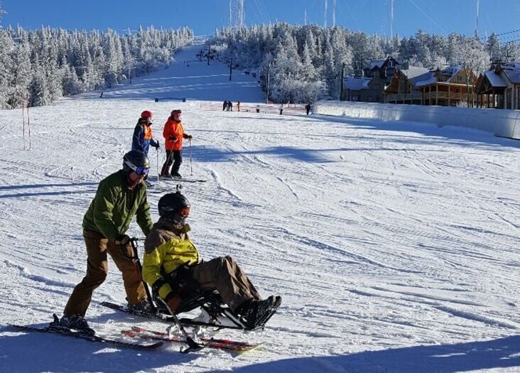 An adaptive sled allows wheelchair users to experience the slopes.