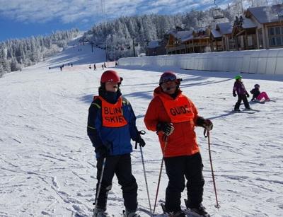 During downhill skiing, Black Hills Ski for Light participants can ski beside volunteers. Others can wear a helmet equipped with audio equipment as a guide directs them side to side.